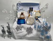 Load image into Gallery viewer, In our large gift box, we have included:
A gorgeous flip-top winter wonderland reusable box, A Plush Winter White Cozy Throw Blanket, A Large Fresh Snowfall fragrant blue candle, A Large Nordic Pine scented handsoap shaped in a silver round globe, A Soft white headband, A double pack of Livegreen Looftahs, Bath & Body's Pure Wonder Lotion and Bath and Body's Pure Wonder Body Wash,