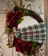 Load image into Gallery viewer, This exquisite wreath is embellished with a captivating handmade buffalo print Sache, graciously welcoming all who approach. Adorned with opulent burgundy silk flowers, lush greens, vibrant berries, and charming pine cones, the wreath showcases nature's finest hues in a harmonious dance of color and texture. The crowning glory is a meticulously crafted, handmade bow, adding a touch of artistry and personal flair to the overall masterpiece.