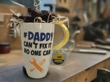 Load image into Gallery viewer, Presenting the "If Daddy Can't Fix It Mug, No One Can" – a mug to warm hearts and lift spirits, filled with love, candy, and cocoa dreams! 
This mug isn't just a mug; it's a vessel of delight, a chalice of joy.  Picture it brimming with candy, a sweet symphony for the taste buds, or cozy hot cocoa, cookies, popcorn, and more swirling with warmth and comfort. 
Now, here's the cherry on top – this mug is a team player.