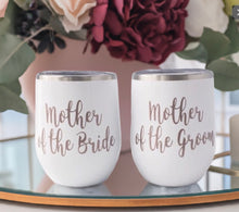 Load image into Gallery viewer, Celebrate with Elegance – Custom "Mother of the Bride" & "Mother of the Groom" Stemless Wine Goblets
Our beautifully crafted stemless wine goblets blend rose gold vinyl with a pristine white background, offering a touch of sophistication. These 14oz stainless steel tumblers keep beverages warm or chilled and come with a secure lid.
Customize yours with names, monograms, quotes, or colors to create a truly personal keepsake. Each tumbler is handmade with care, ensuring top quality.