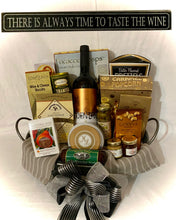 Load image into Gallery viewer, A carefully selected bottle of wine takes center stage, nestled within a beautifully designed basket tray, perfect for elegant wine service. We've thoughtfully lined the basket with two kitchen towels and filled it with an array of delectable treats. The selection includes Cracker Crisps, Caramel Popcorn, Water crackers, Beef sticks, Wine and Cheese Biscuits, Chocolates, Cookies, mustard and jam, Pretzels, and so much more.