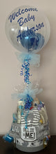 Load image into Gallery viewer, The base price for a balloon is $8.00 plus tax. It comes with a balloon, a stick, and 4 internal balloons. You can customize the balloon with us! We also carry latex and mylar balloons with air!  The "Welcome Baby Anderson" balloon was made with pearl white and iridescent blue balloons inside. The name is made of blue vinyl with a baby elephant blowing hearts up. Then the balloon was wrapped in white tulle and a balloon stick wrapped in ribbon was placed into the baby gift basket for a baby shower gift.