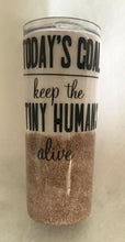 Load image into Gallery viewer, "Today's Goal"... keep the Tiny Humans alive is a tumbler that was a special order for a teacher. We love the quote but the truth is our teachers all work very hard we respect each and every one!  This is a stainless tumbler it is great for any hot or cold drink and can hold 20 fluid ounces with a lid. It is decorated with vinyl, extra fine glitter, and resin. These tumblers can be ready in one to two weeks.