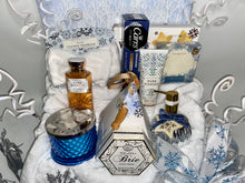 Load image into Gallery viewer, In our large gift box, we have included: A gorgeous flip-top winter wonderland box reusable box, A Winter White Cozy Throw Blanket, A Large Fresh Snowfall fragrant blue candle, A Large Nordic Pine scented handsoap shaped in a silver ornament shape, A Soft white headband, A double pack of Livegreen Looftahs,&nbsp;Bath &amp; Body&#39;s Pure Wonder Lotion and Bath and Body&#39;s Pure Wonder Body Wash, A Cozy pair of socks, A box of Walker cookies, creamy Brie cheddar cheese with a cheese spreader, Crispy water cracker