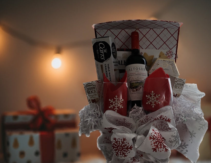 Celebrate the season with the Snowflake Splendor Gift Box, a stunning metallic red flip-top box adorned with shimmering silver snowflakes. This reusable box is filled with an elegant assortment of holiday treats, including: