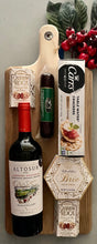 Load image into Gallery viewer, Indulge in the perfect pairing of flavors and elegance with our &quot;Vine &amp; Graze Charcuterie Board&quot; or &quot;Savor &amp; Sip Board&quot;. This delightful gift includes:

A large, stylish charcuterie board with a handle (20&quot; x 8.5&quot; x 1/2&quot;)—perfect for entertaining or as a keepsake.
Your choice of red or white wine to complement every bite.
Creamy Brie cheese spread and crisp water crackers for a classic pairing.
Decadent Cashew Roca for a touch of sweetness.
A savory sausage stick to round out the board.