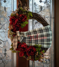 Load image into Gallery viewer, This exquisite wreath is embellished with a captivating handmade buffalo print Sache, graciously welcoming all who approach. Adorned with opulent burgundy silk flowers, lush greens, vibrant berries, and charming pine cones, the wreath showcases nature&#39;s finest hues in a harmonious dance of color and texture. The crowning glory is a meticulously crafted handmade bow, adding a touch of artistry and personal flair to the overall masterpiece.