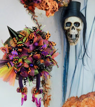 Load image into Gallery viewer, Get ready to add a dash of wackiness to your Halloween decor with our spooktacular &quot;Wacky Witch Wreath&quot;! Made with love and a touch of enchantment, this one-of-a-kind wreath is all set to cast a spell on your door or wall. With its mesmerizing mesh and vibrant Halloween ribbons, it&#39;s the ultimate invitation for all the trick-or-treaters. And don&#39;t forget the whimsical witch&#39;s hat, legs, and broom – they&#39;re here to make your visitors smile and cackle with delight.