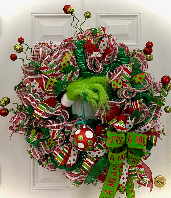 The Grinch Strikes! Adding Some Sass to this Awesome Handmade Wreath! Picture this: a seriously cool mesh and ribbon wreath, all decked out with vibrant colors, hanging out on a door or wall. But wait for it... who's sneaking in? The Grinch! That cheeky green guy just can't resist adding his own touch to this already awesome wreath!This wreath? It's a total dazzler— 36 inches of holiday cheer, filled with ribbons and ornaments in the raddest shades of red, green, and white.