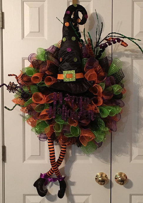This Happy Halloween Wreath is a colorful mesh wreath perfect for any room, door, or wall. It's the kind of wreath that welcomes all your ghoulish friends with vibrant colors. It's bright and decorated with a witch's hat, witches' legs, and a variety of embellishments and colorful mesh. It measures approximately 40