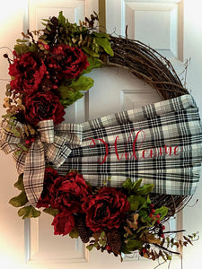 Welcome Wreath is a beautifully handmade wreath with silks, berries, pinecones, a handmade welcome sash made of fabric and printed vinyl, and a beautiful bow on an approximately 24" oval grapevine wreath. This wreath says welcome to all your guests and would look great on any door or wall as decor. Grapevine wreaths are all different in sizes therefore if ordering by two for a double door we will do our best to get them as close as possible in size. We can deliver locally and ship.