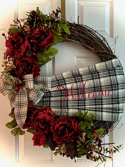 Welcome Wreath is a beautifully handmade wreath with silks, berries, pinecones, a handmade welcome sash made of fabric and printed vinyl, and a beautiful bow on an approximately 24