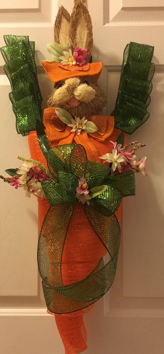 Hop into the whimsical world of Bunny in a Carrot – because who needs a plain old welcome mat when you can have a bunny wearing a hat? This cutie-patootie is not your average door or wall decoration; it's a handmade mesh masterpiece ready to scream 