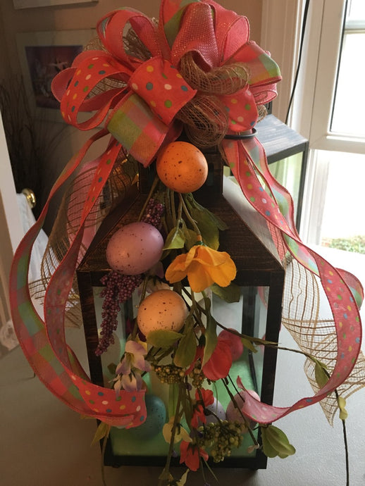 Spring Lantern is a wonderful centerpiece for your dining table, side table, or countertop. This lantern has a large led battery-operated candle decorated with Easter eggs, silks, and a beautiful handmade bow. It measures appx. 15