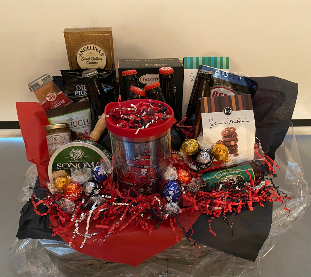Our Tampa Bay Gift Basket was a custom-made gift basket for a true fan! Preparing for a game and having a gift basket like this will make any tailgater feel over the top! We have added sweet and savory treats along with a special selection of memorabilia for this fan! Included reusable basket, Tampa Bay reusable cup, crisps, peanuts, cheese straws, cheese, beer, (we cannot ship adult beverages but will substitute for extra snacks) 