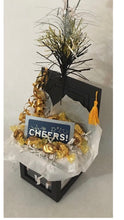 Load image into Gallery viewer, Graduation Cap Photo Gift Box is the perfect gift no matter what age your graduate is. We can customize this gift with a variety of candy, gift cards, and more. This photo box includes candy and a card. This is just an example of gifts. Let us know if we can customize this for you. We can add this gift box to another gift as well. Your gift will come cello wrapped, with a notecard and handmade bow. We can ship nationwide. Money cards may be added such as Amazon cards, Starbucks, Stores, and more.
