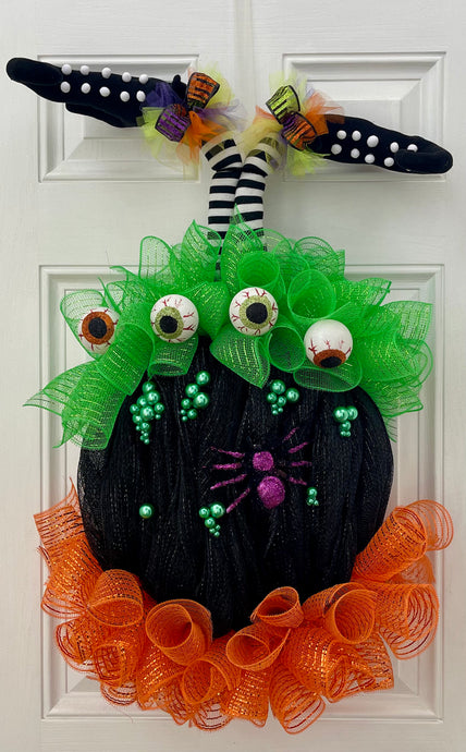Our Witch in Cauldron is a Halloween “BEST SELLER” This one of kind door or wall décor will make your little goblins laugh out loud! This handmade mesh wreath is perfectly decorated with witches' legs, spiders, bubbles, eyeballs, and flames in a handmade mesh cauldron. This wreath says it all 