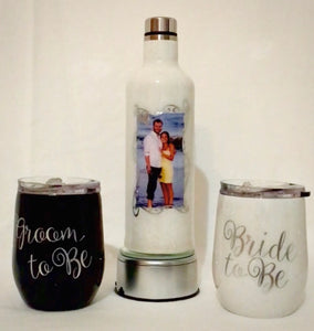 "Bride & Groom To Be" is a stainless steel set of stemless wine glasses and a bottle that holds your wine chilled or at room temperature for hours. This was personalized for this couple and can be personalized or designed any way you like. We can add monograms, names, and quotes. These come in a gift box ready to be wrapped for your special recipients. Perfect for engaged couples, weddings, anniversaries, or just because! All ink, vinyl, and micas are sealed with layers of FDA-approved, food-safe Epoxy.
