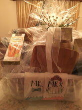 Load image into Gallery viewer, This particular basket included kitchen towels, a cutting board, a strainer, a cheese grater, pasta, sauce, breadsticks, salad spinner, cheese, crackers, cookies, chocolates, kitchen utensils, and more! Customize this gift to fit the couple’s style and needs, with a variety of container options available. Look in the dropdown for price points to start creating the perfect gift!