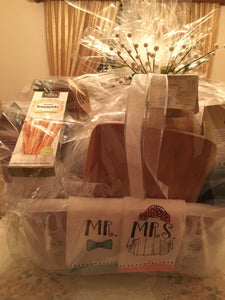 This particular basket included kitchen towels, a cutting board, a strainer, a cheese grater, pasta, sauce, breadsticks, salad spinner, cheese, crackers, cookies, chocolates, kitchen utensils, and more! Customize this gift to fit the couple’s style and needs, with a variety of container options available. Look in the dropdown for price points to start creating the perfect gift!